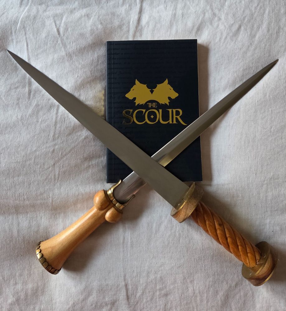 'The Scour' in gold, on black-covered novella. A bollock dagger and a rondel dagger are crossed over it.