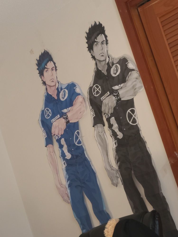Two paper cutouts of Sigma Klim from the video game Zero Escape: Virtue's Last Reward. The one on the left is in full color while the one on the right is in black and white.