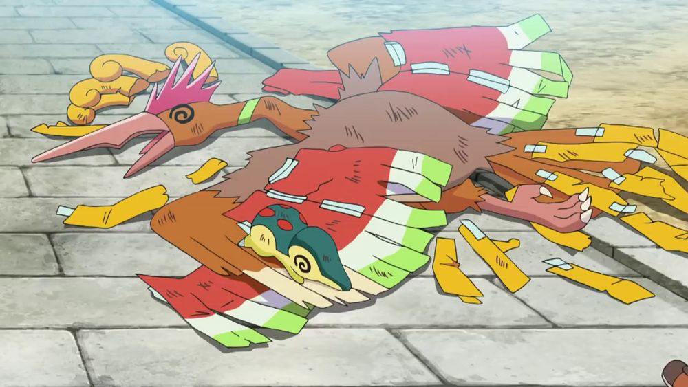 Fearow dressed as Ho-Oh and Cyndaquil lying on the floor very dizzy.
