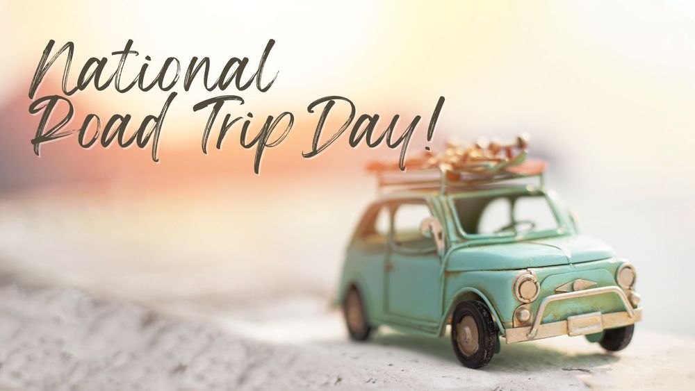 Vintage toy car with luggage on the roof parked on a sandy surface, with the text "National Road Trip Day!" in a whimsical script.