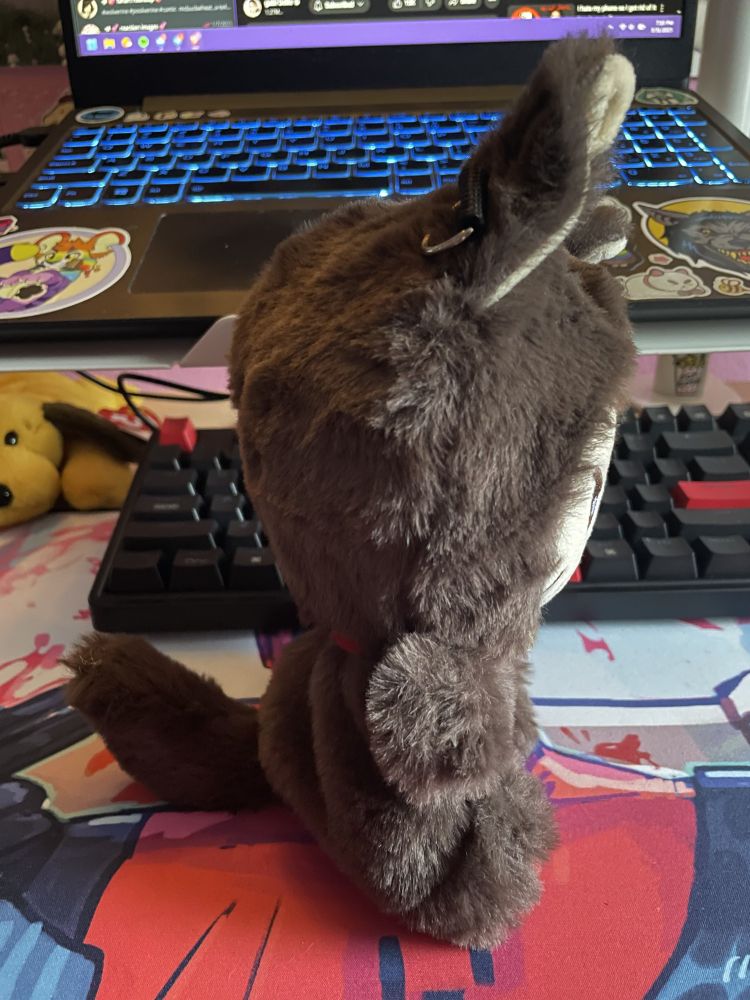 side view of sauchelle wolverine plush in brown big bad wolf costume. his tail is big and fluffy.