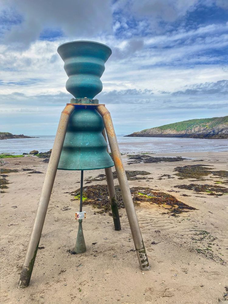 Tide bell on sandy beach 