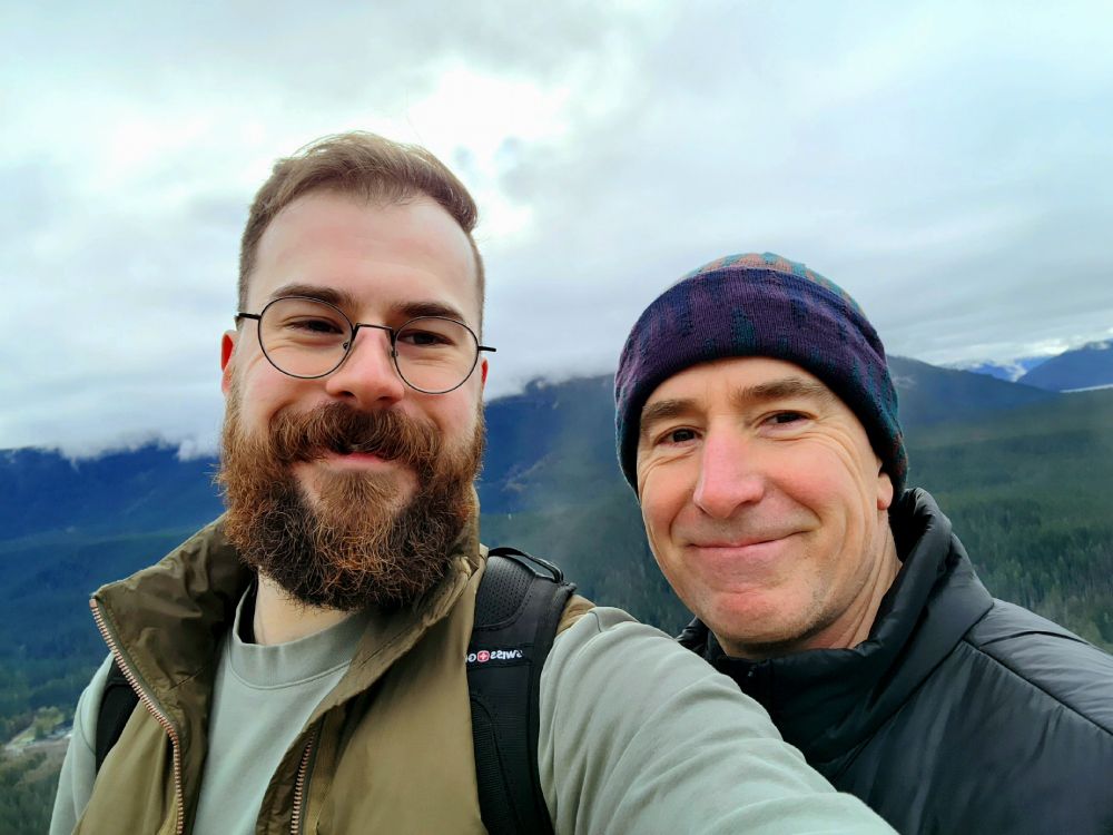 Me and my dad (older me) smiling at the camera at one of the peaks on the trail
