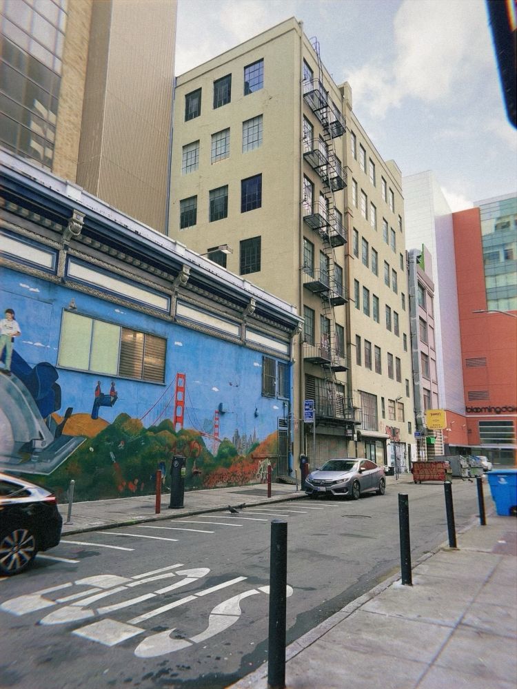 A mural of the Golden Gate Bridge in an alleyway