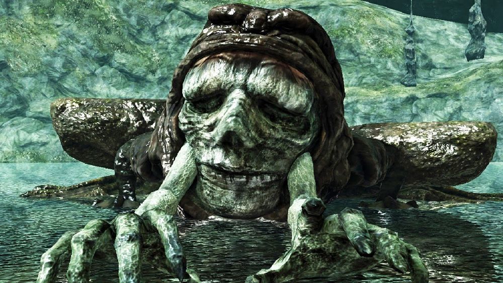 Dark Souls 2 boss Demon of Song, a frog like monster with a face and hands coming out of the mouth of the frog's body.
