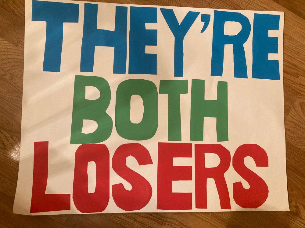 Protest sign: They’re both losers 