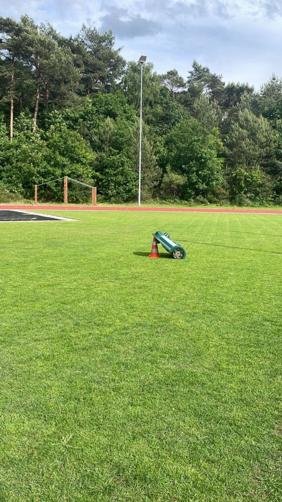 Onze robotmaaier is vastgelopen op een pylon en staat nu op zijn achterwielen tegen de pylon aan.