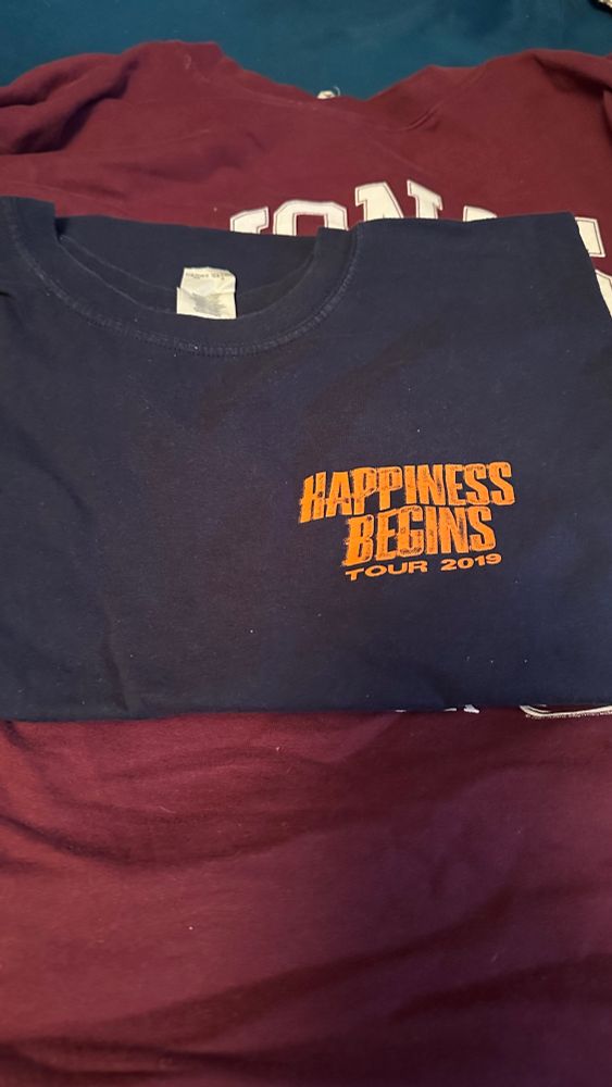 navy blue shirt with “happiness begins tour 2019” on the top left corner