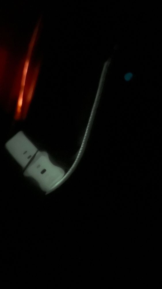 a watch band, phone chord, and a ring all glowing in the dark 