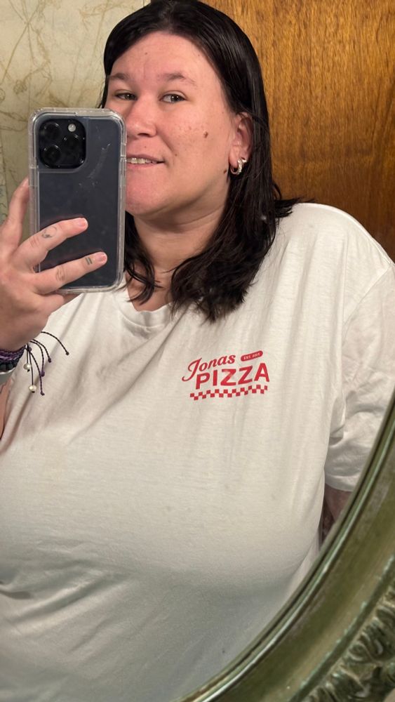 a mirror selfie of me on a white shirt with “jonas pizza” written in red in the corner 