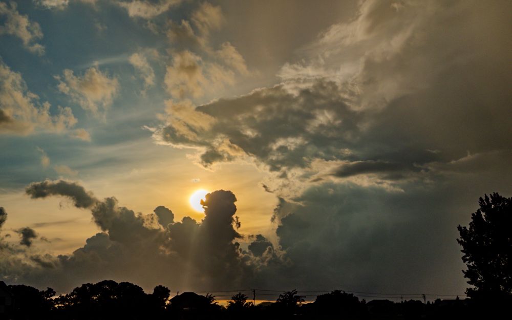 Sun peeping out behind some leftover storm clouds. 