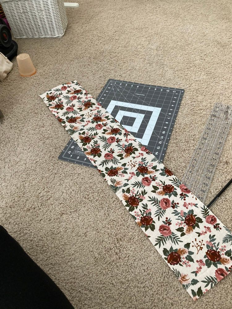 A long piece of fabric layer out onto a carpeted floor.