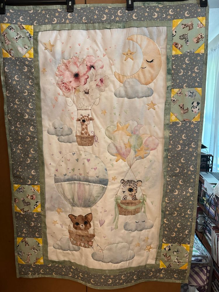 The image shows a panel with baby animals in hot air balloons surrounded by moon and star fabric and six snowballed squares.