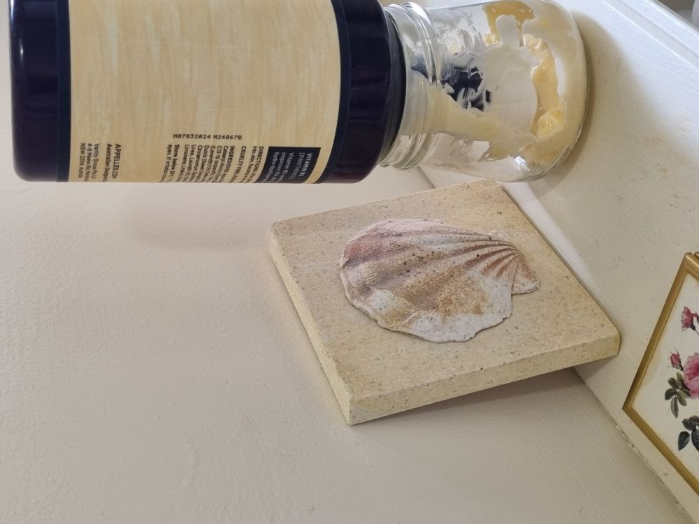 Bathroom lotion pump bottle. Pump removed. Bottle upside down draining into a jar.