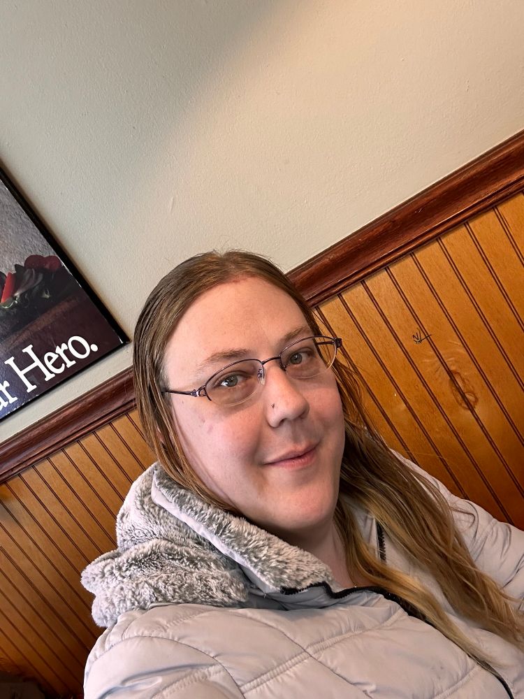 Selfie of June hair down with a grey jacket. 