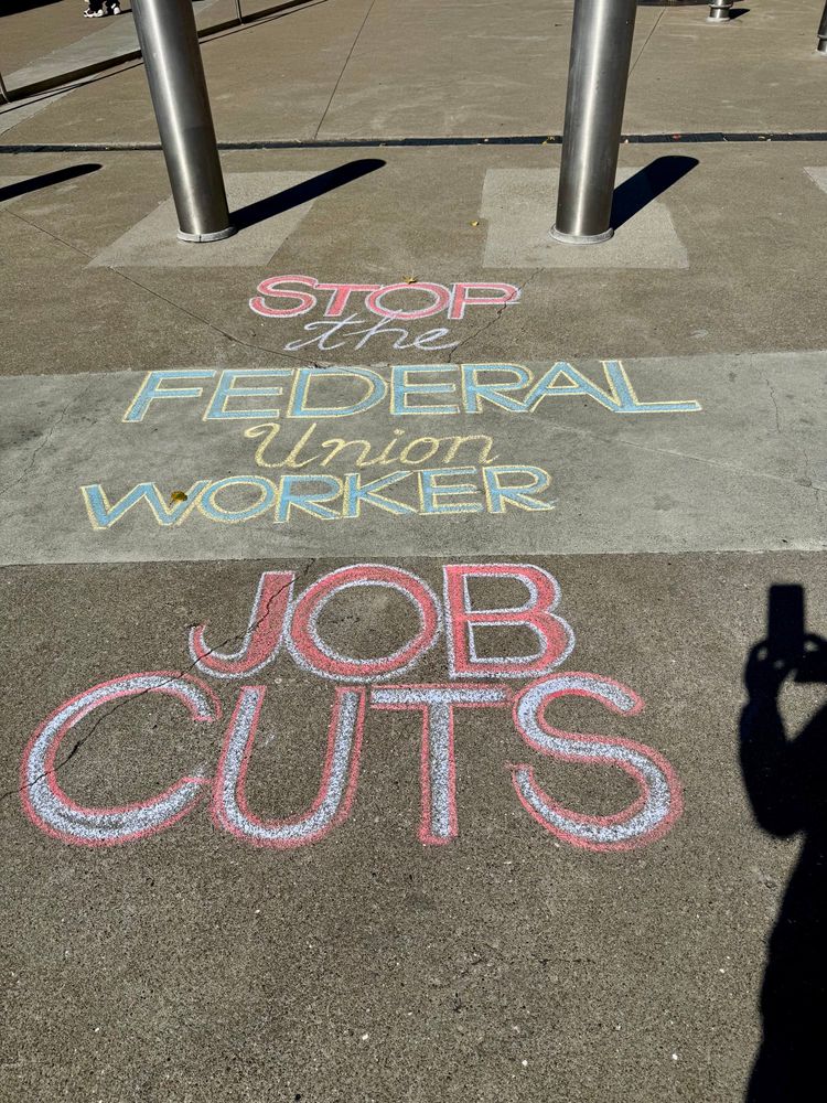 Chalk on sidewalk: Stop the Federal Union worker job cuts