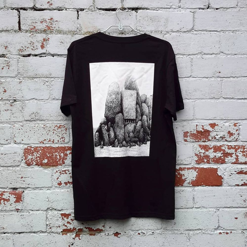 photo: black t-shirt with back print in white, showing a mysterious structure