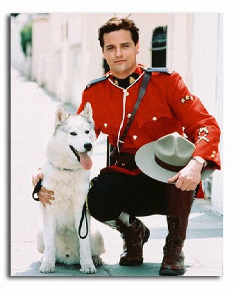 Media still shot from the show "Due South" featuring Paul Gross as Constable Benton Fraser posing next to the dog playing the character's fiction "pet" wolf Diefenbaker 