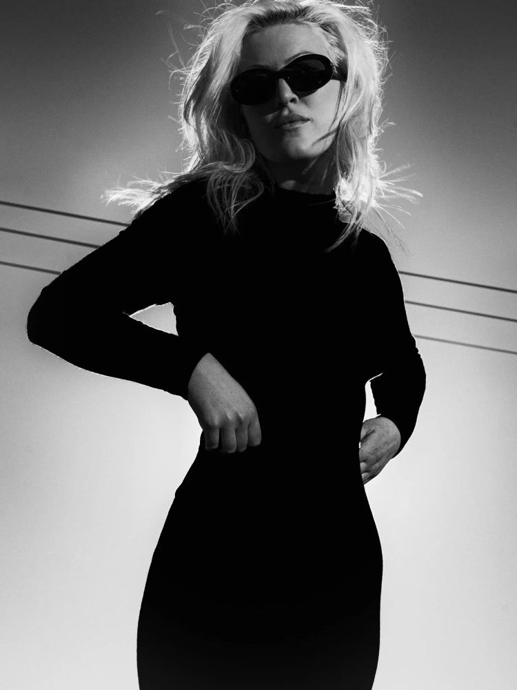 Olivia Nuzzi posing against...telephone/electrical lines?

Caption: "Over a decade, Nuzzi cared less about breaking news than about exposing the foibles and vanity of Trump and the people within his orbit."