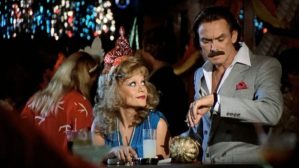 A vapid blonde makes eyes at a leisure suited guy with a mustache who'll eventually kill her because he's Evil from New Year's Evil. 