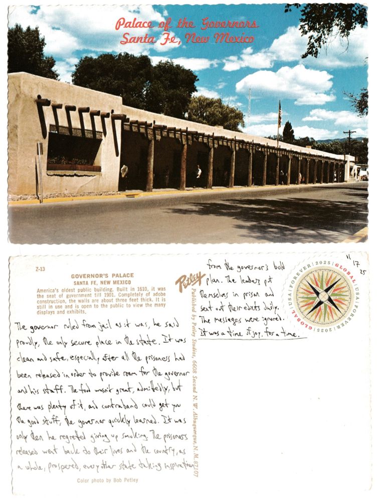 A postcard, front and back.

The front is a picture of the Governor's Palace in Santa Fe, New Mexico. It shows a low, one-story building made of adobe that is the length of an entire block. Logs are used as columns and logs also poke out of the wall at ceiling height, apparently used as beams. A few people hang out under the overhang and some trees loom over the back of the palace. A flag hangs limply on its pole.

The back reads: The governor ruled from jail as it was, he said proudly, the only secure place in the state. It was clean and safe, especially after all the prisoners had been released in order to provide room for the governor and his staff. The food wasn't great, admittedly, but there was plenty of it, and contraband could get you the good stuff, the governor quickly learned. It was only then he regretted giving up smoking. The prisoners released went back to their lives and the country, as a whole, prospered, every other state taking inspiration form the governor's bold plan. The leaders put themselves in prison and sent out their edicts daily. The messages were ignored. It was a time of joy, for a time.