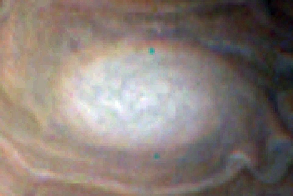 Close-up view of a bright, oval-shaped storm system with cyclonic characteristics on the planet Jupiter.
