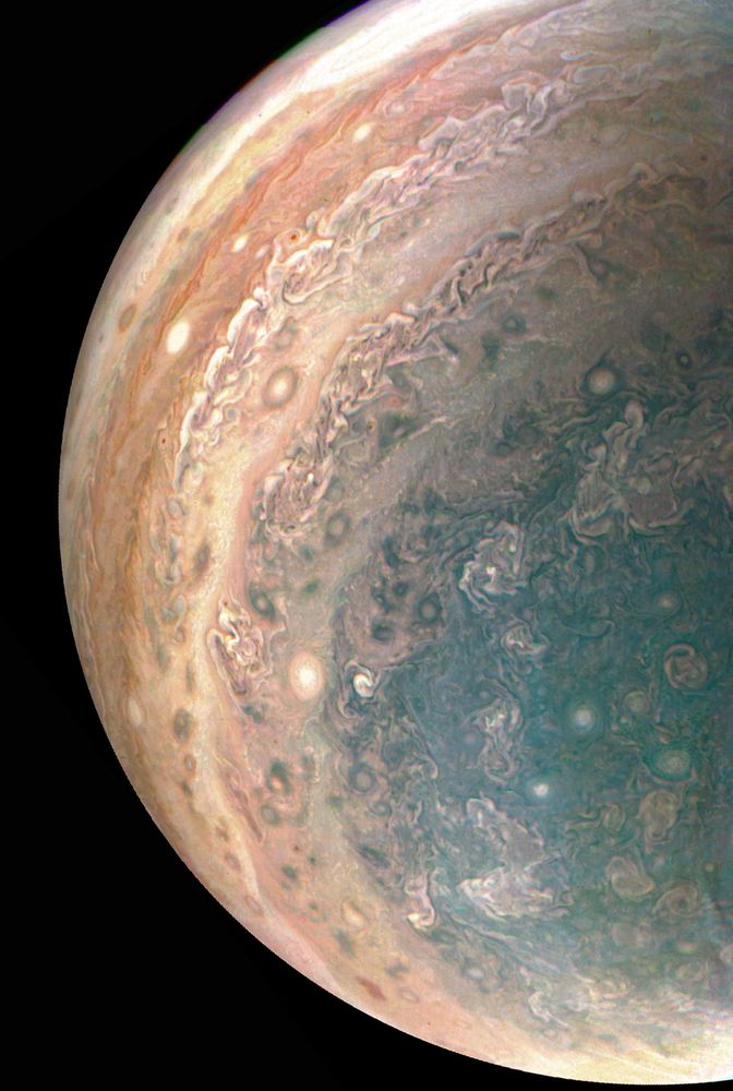 Wide view of Jupiter's southern hemisphere, including its uniquely coloured polar region and multiple storms of various shapes and sizes.