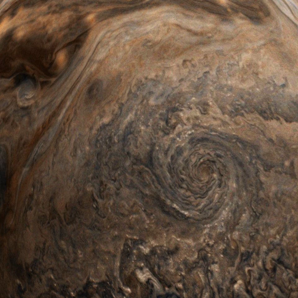 Close-up view of a cyclonic storm on Jupiter and the dark clouds surrounding it.