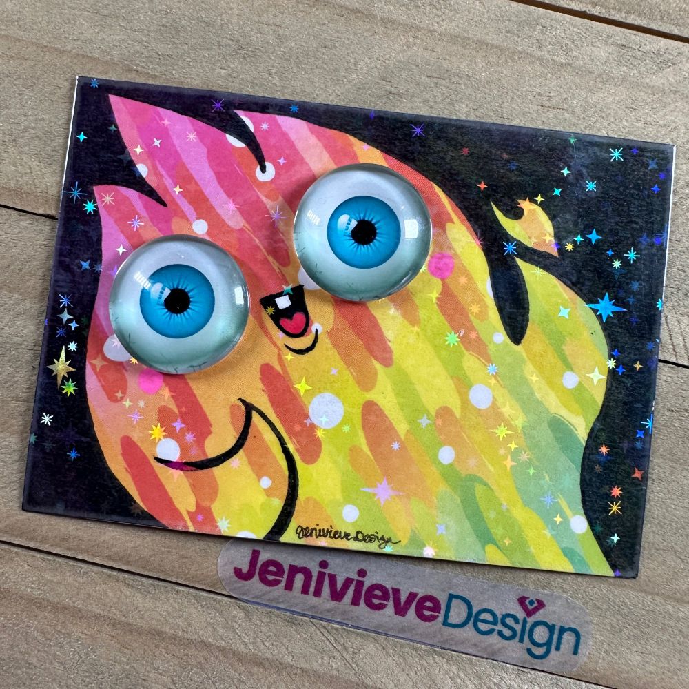 Illustration of a happy fire ghost using brush pen, scrapbooking paper, and glass eye cabochons by Jenivieve Design.