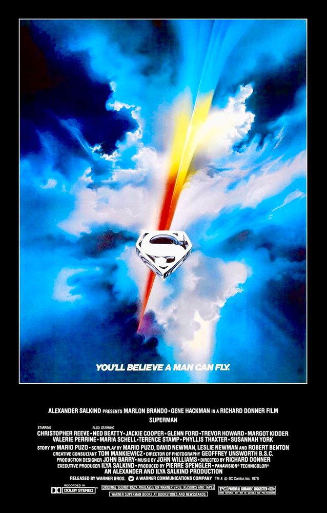 Poster art for the 1978 movie, “Superman - The Movie” directed by Richard Donner and starring Christopher Reeve. Image shows a crystalline rendering of the Superman “S” logo set against a blue, cloud filled sky and a diagonal red and yellow streak cutting through the clouds. The tagline reads: “You’ll Believe A Man Can Fly”