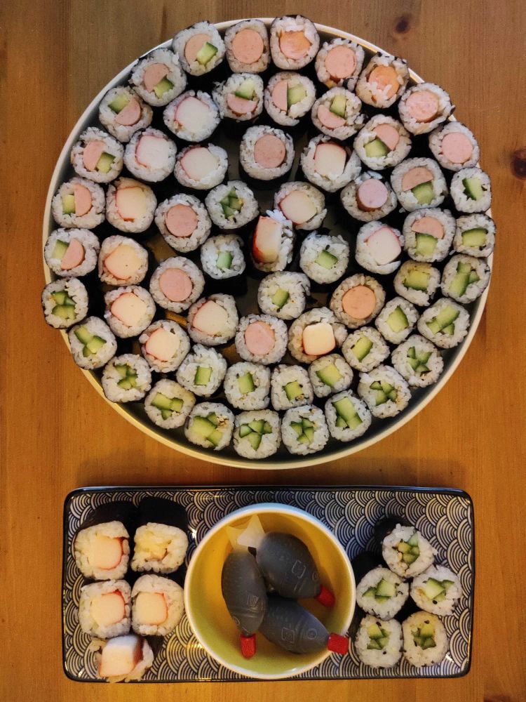 Ein riesiger Teller Sushi und eine kleine Platte mit Sojasoße daneben.