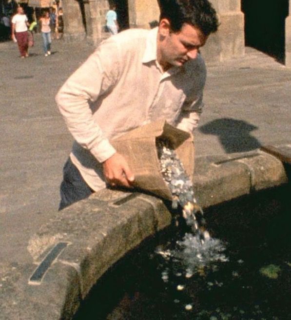 Man throwing pennies in a fountain