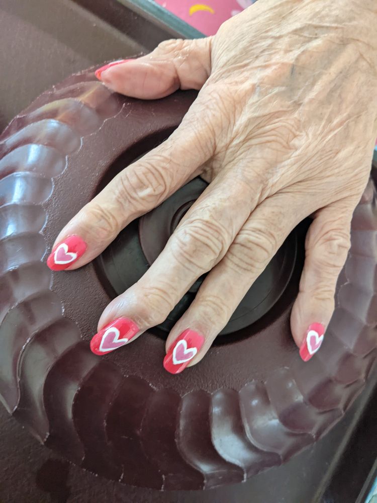 a nail design featuring pale pink hearts edged in white on a hot pink background