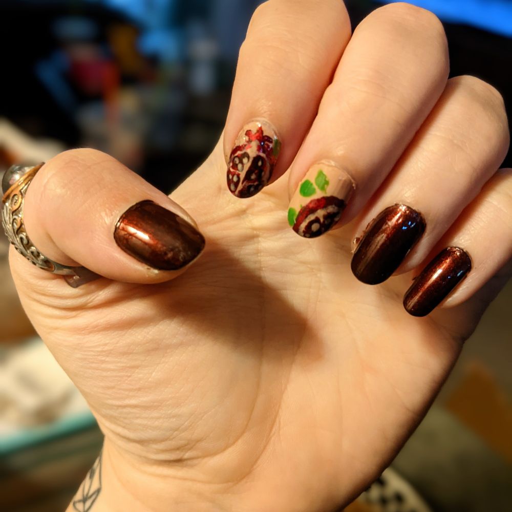 a nail design featuring sliced pomegranates and dark red solid nails