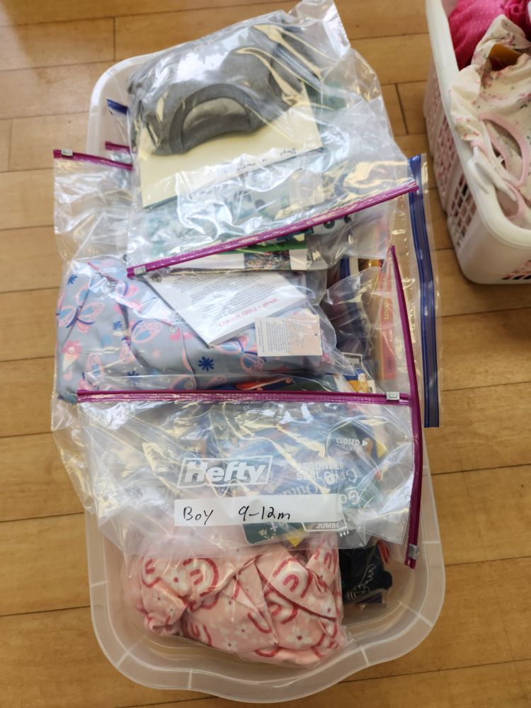 Plastic tote full of kids pajamas and books ready for distribution to charity. 