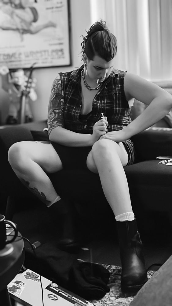 A black and white photo of a trans woman injectioning herself with estrogen