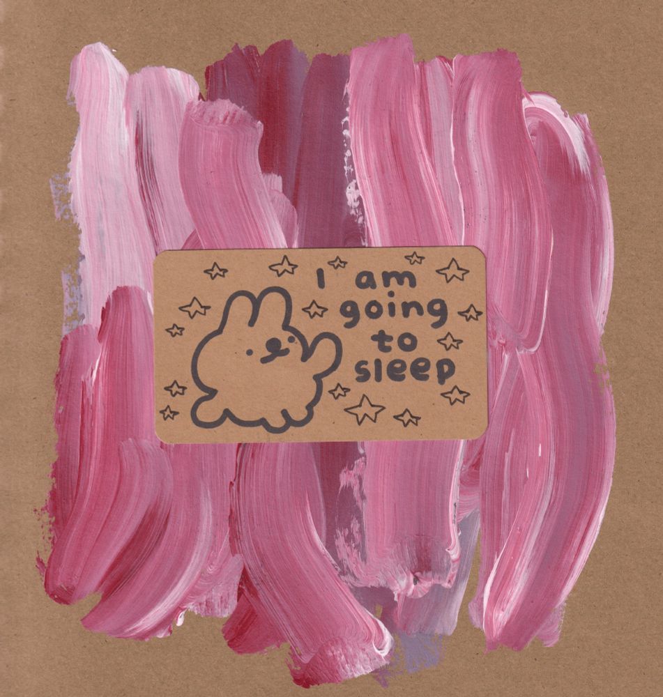 A small drawing of a bunny on brown paper with several red and white paintstrokes behind it. Text on the drawing reads: 