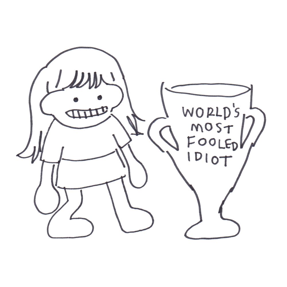 A grimacing woman stands next to a large trophy cup, which reads, "world's most fooled idiot".