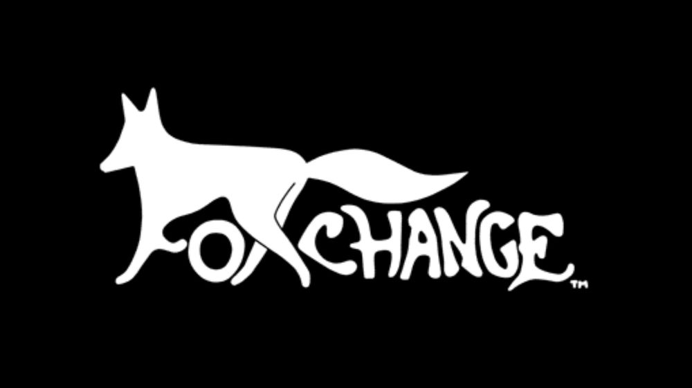 A screenshot of "Cave Dig 3" showing the Foxchange logo splash on a black background. The "F" is made from the fox's fore legs and the "X" is formed by the fox's hind legs.