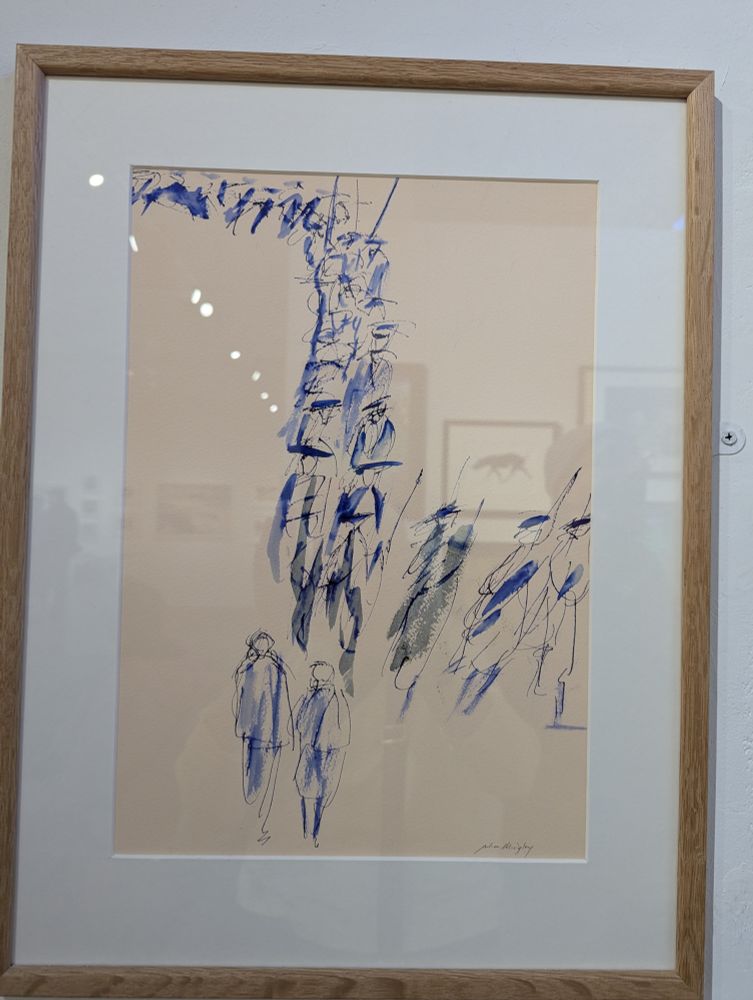 Watercolour painting by RWS member Julia Midgeley on display at Bankside Gallery London. The framed painting shows parade of robed figures loosely drawn/painted in blue watercolour and black ink. Title is "Graduation". https://www.royalwatercoloursociety.co.uk/ Photo by Ellen Friedman