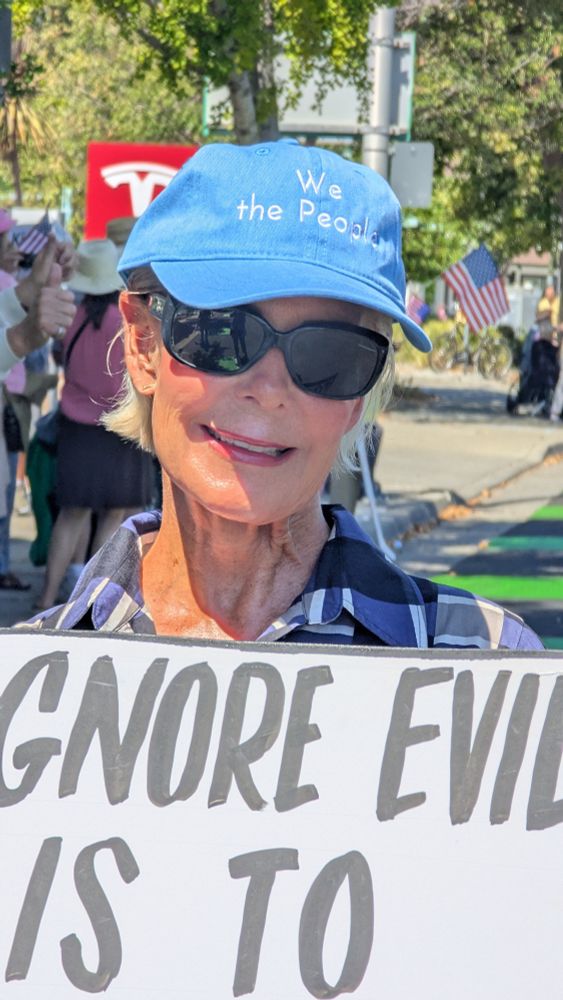 Protester wearing blue cap that reads 