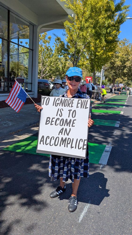 Protester wearing blue cap that reads 