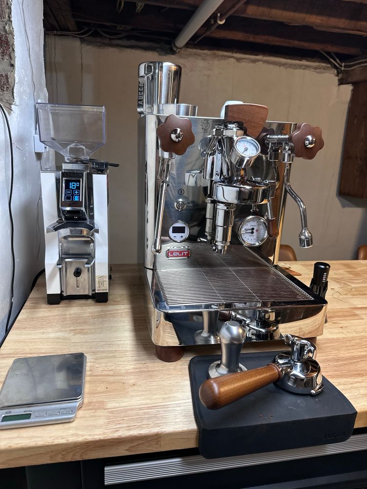 Image of a chrome lelit espresso maker and an espresso grinder. 