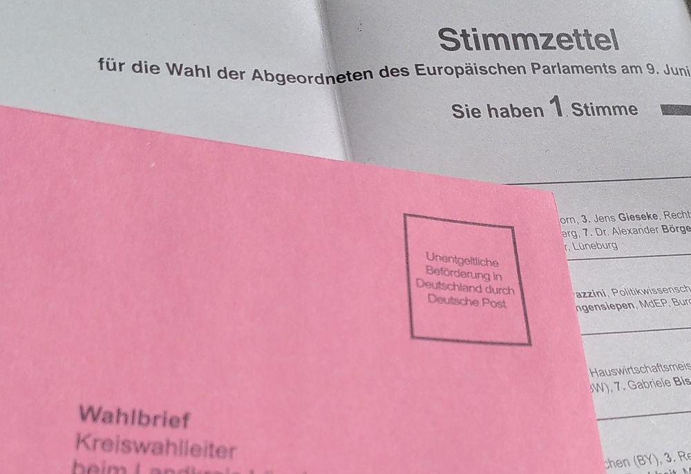 Auf dem Briefwahlzettel zur Europawahl liegt der dazugehörige rote Umschlag (Bildausschnitt)
