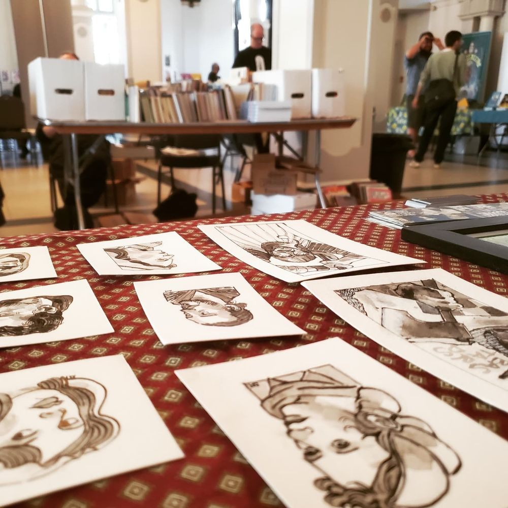 table covered in miniature portraits ink and watercolour