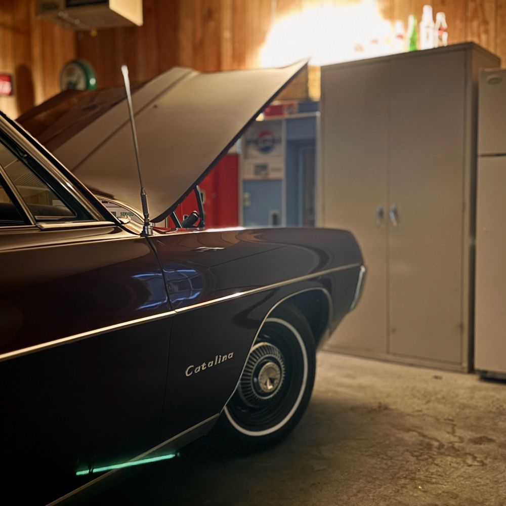 Vintage Pontiac Catalina parked in a garage with the hood raised.