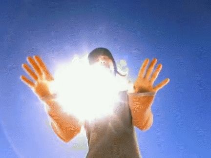 a person wearing orange gloves is looking at the sun