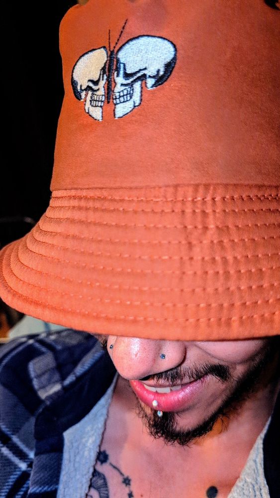 Picture of me wearing a red bucket hat with a double skull moth in the middle.
