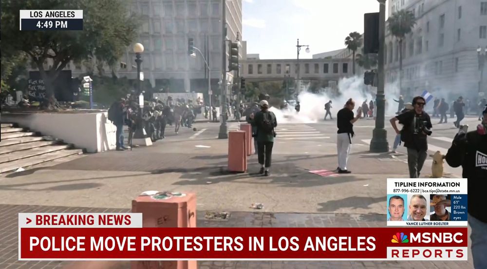 LA protests with tear gas in the distance. People are spread out.

The Chyron says "Police move protesters in Los Angeles".

The time says that it's 4:49 pm. There is a box showing the tip line for the Minnesota assassin Vance Luther Boelter.