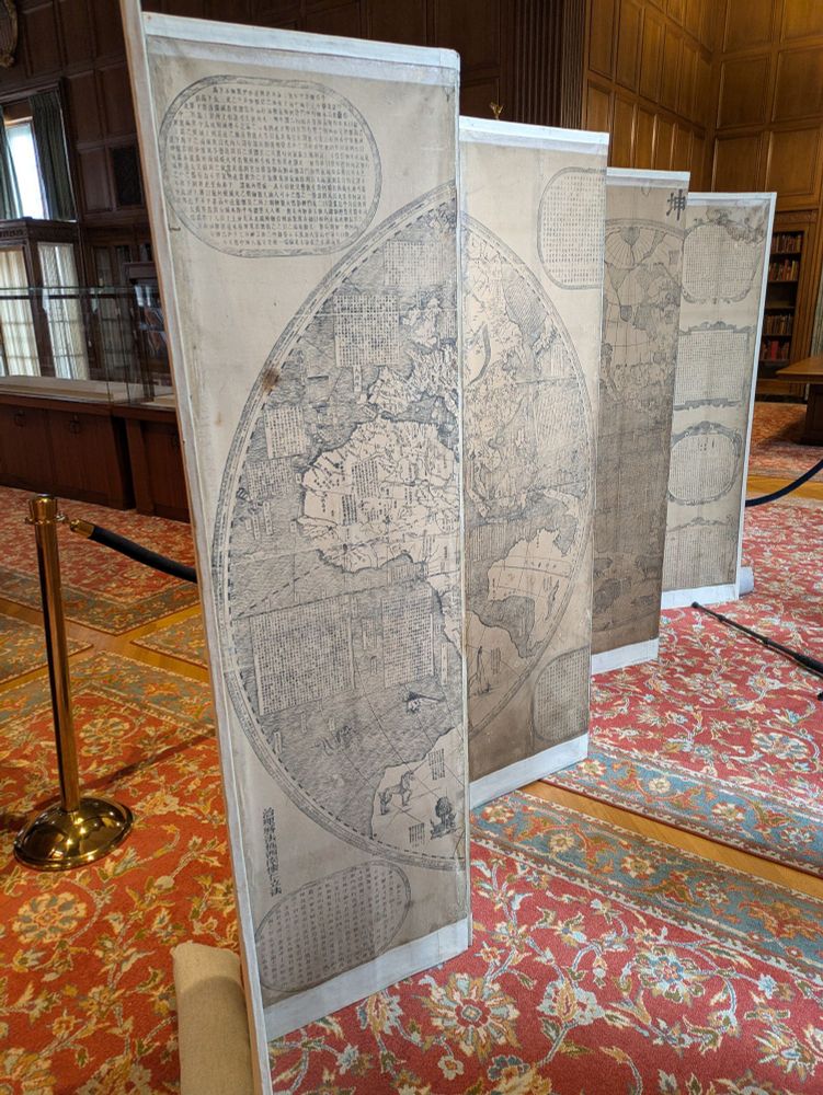 Double hemisphere map of the world mounted on a screen.
